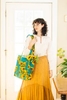 A women models a tote and other apparel during a catalog photo shoot for April Cornell.