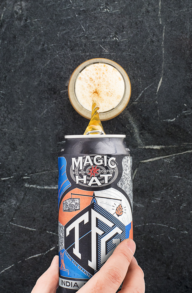 Hand pouring Magic Hat Brewing Company TFG India Pale Ale beer into a glass.