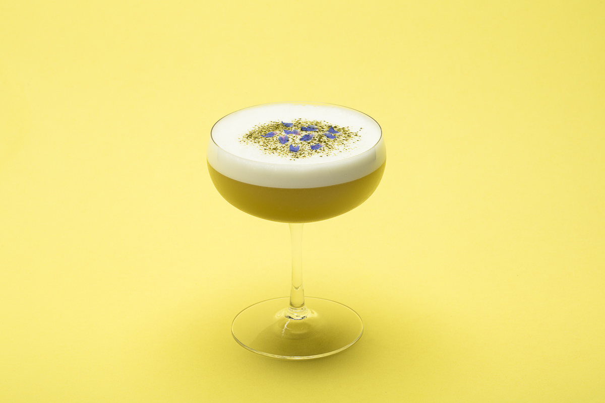 Stonecutter Spirits egg white cocktail on a yellow background. By commercial photographers at JAM Creative.