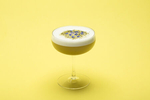 Stonecutter Spirits egg white cocktail on a yellow background. By commercial photographers at JAM Creative.