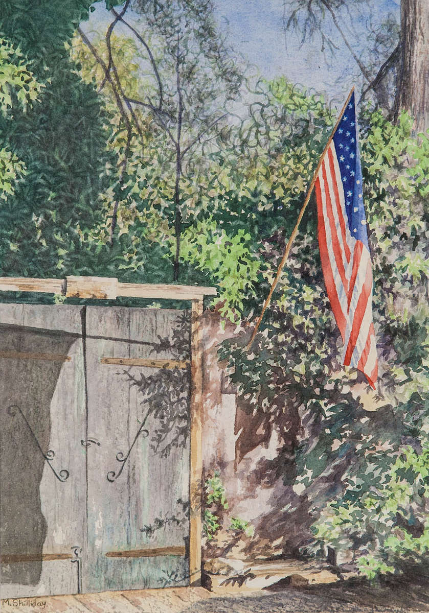 Old gated enterance of a Santa Barbara house with American Flag. 