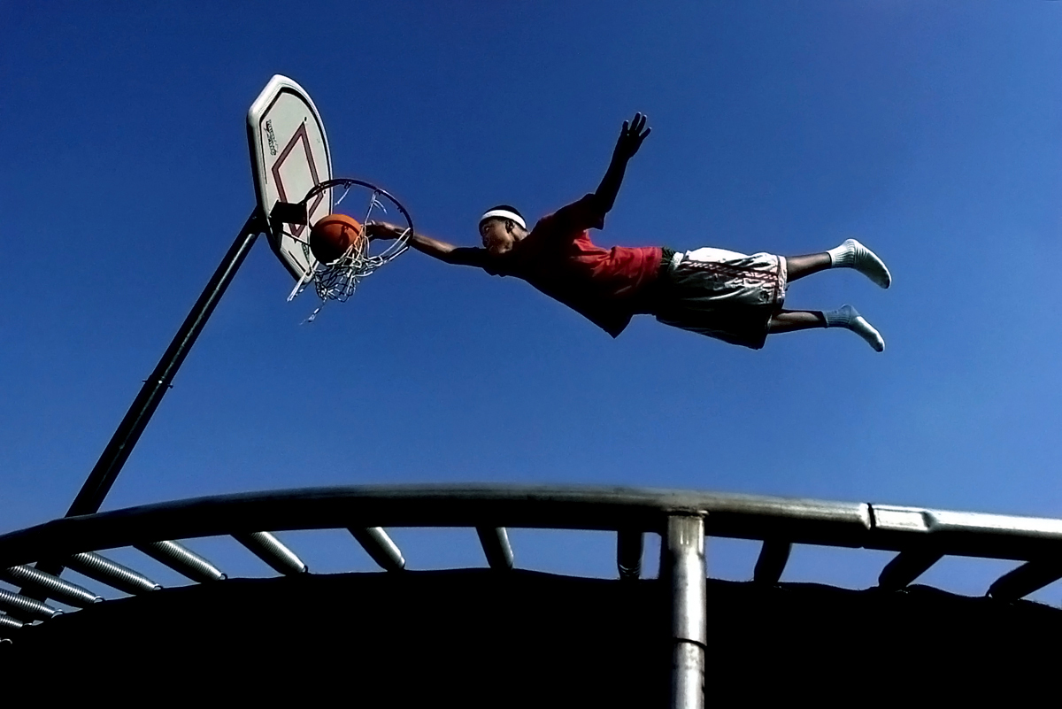 Myles McCadney, 15, glides through the air and jams the ball into the basket during a trampolinedunk contest with his friends in San Bernardino, Calif. (The Press-Enterprise/ Mark Zaleski) 
