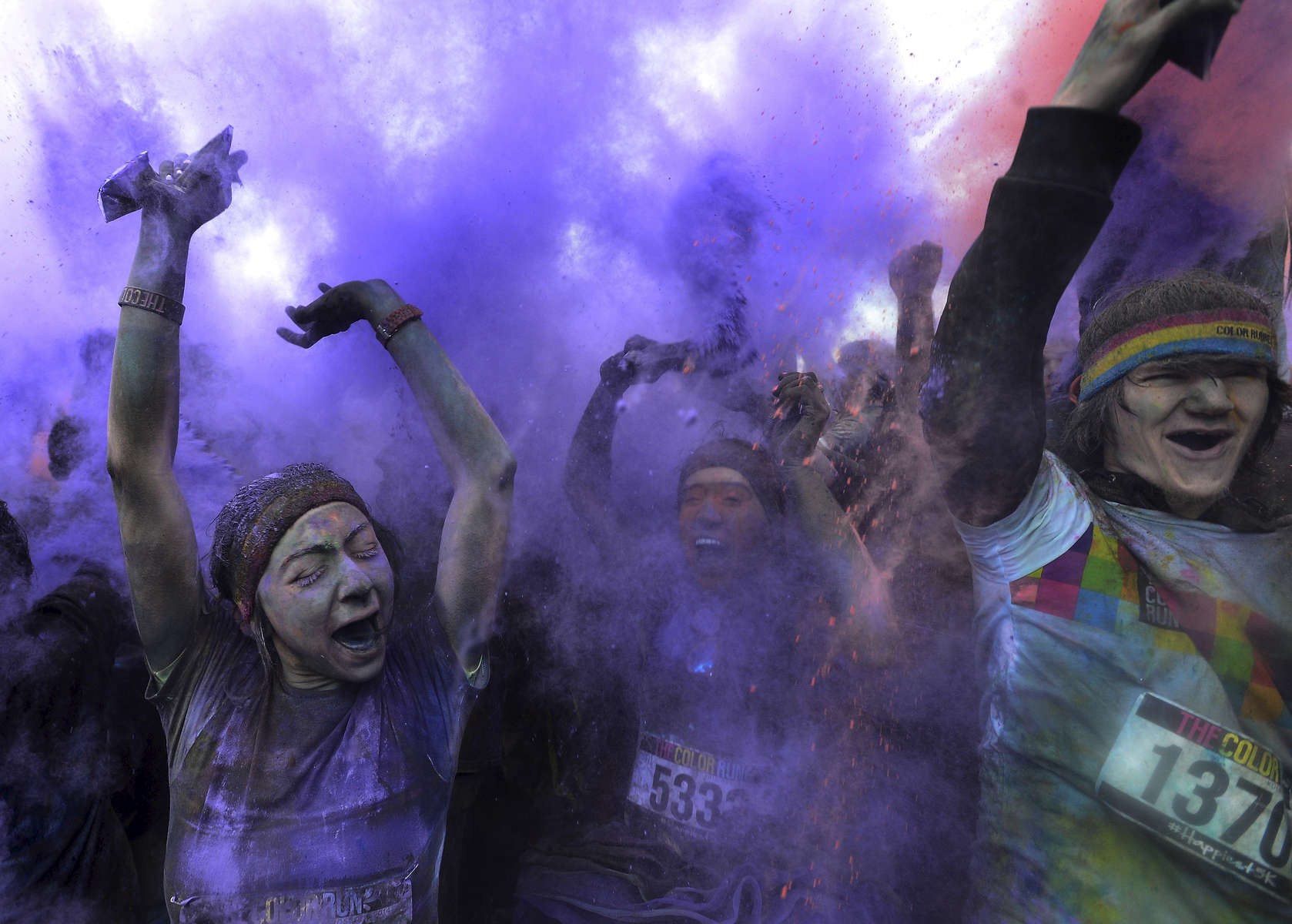 Runners celebrate as purple powder coats themat the end of the Color Run in Nashville, Tenn. (Mark Zaleski/ For The Tennessean)