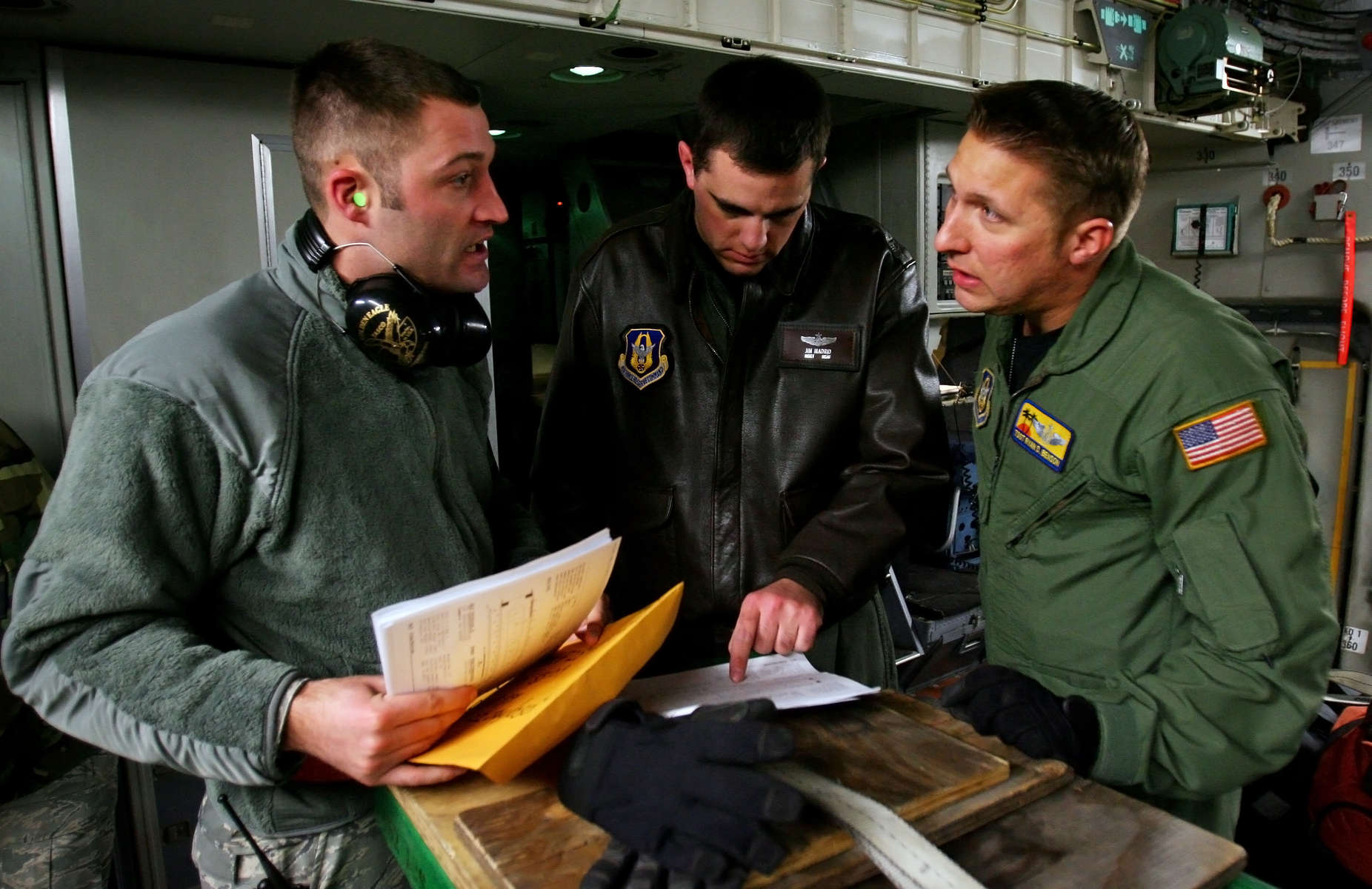 March Air Reserve Base C-17 aircrew Master Sgt. James, center, and Tech Sgt. Ryan Benson brief with Bill Taylor of McChord Air Force Base ground crew before loading humanitarian aid materials forHaiti after landing at McChord Air Force Base in Wash. (The Press-Enterprise/ Mark Zaleski)