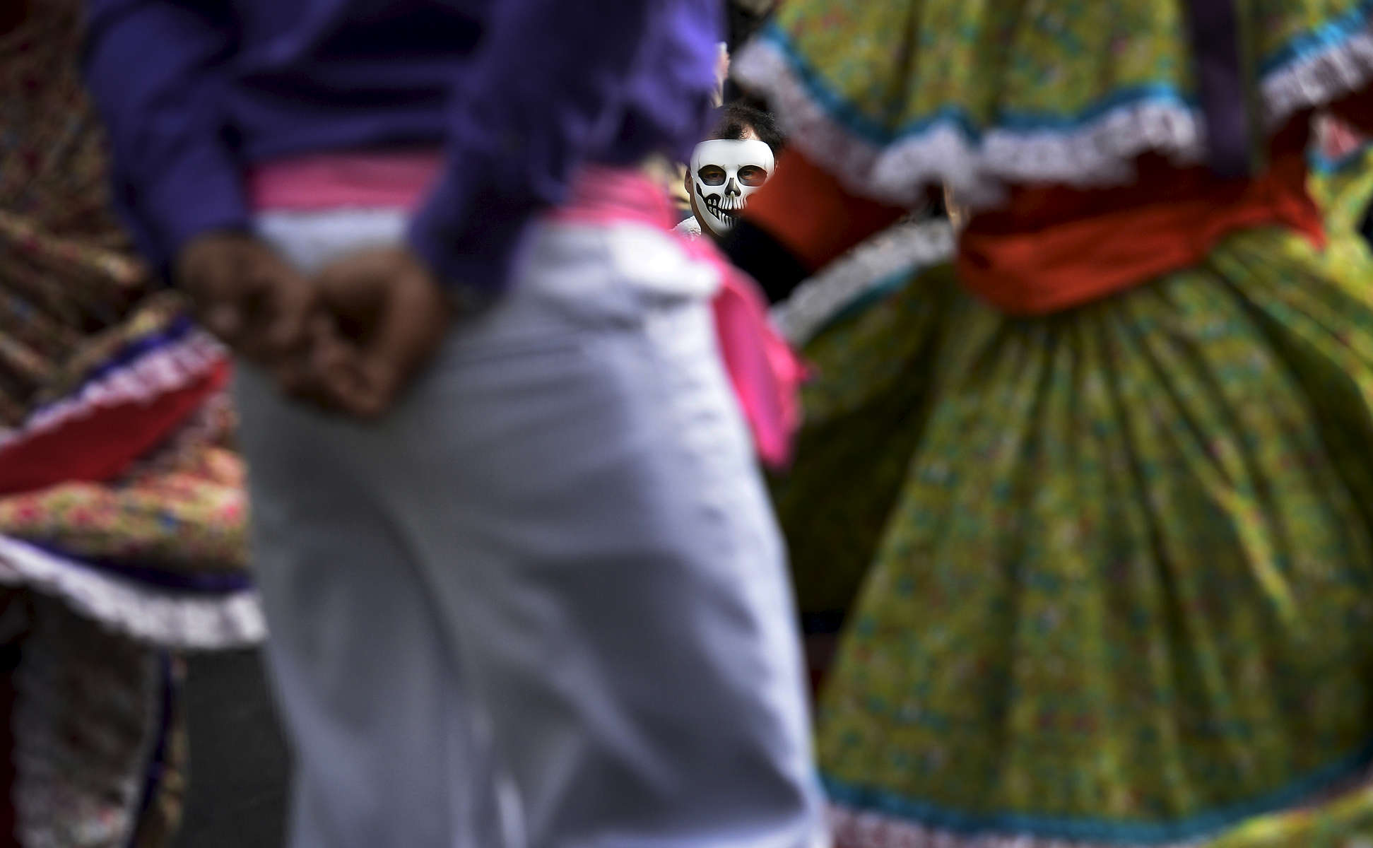 Raul Madero wears a calaveras mask while watching the Destellos Culturales de Nashville perform during the El Dia de los Muertos fall festival at Cheekwood Botanical Garden and Museum of Art. (The Tennessean/ Mark Zaleski)