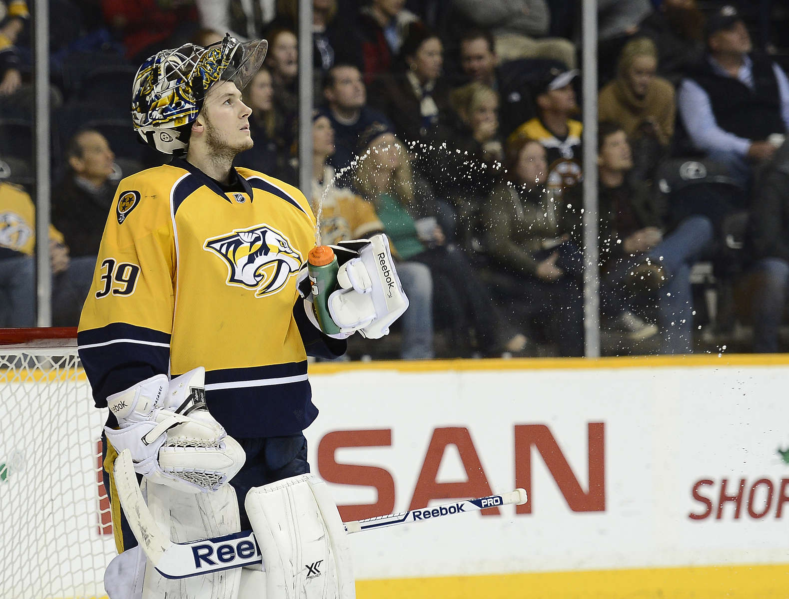 Nashville Predators goalie Marek Mazanec squirts water out of his bottle after allowing a goal against the Boston Bruins in the third period of an NHL hockey game on Dec. 23, 2013, in Nashville, Tenn. The Bruins won 6-2. (AP Photo/Mark Zaleski)