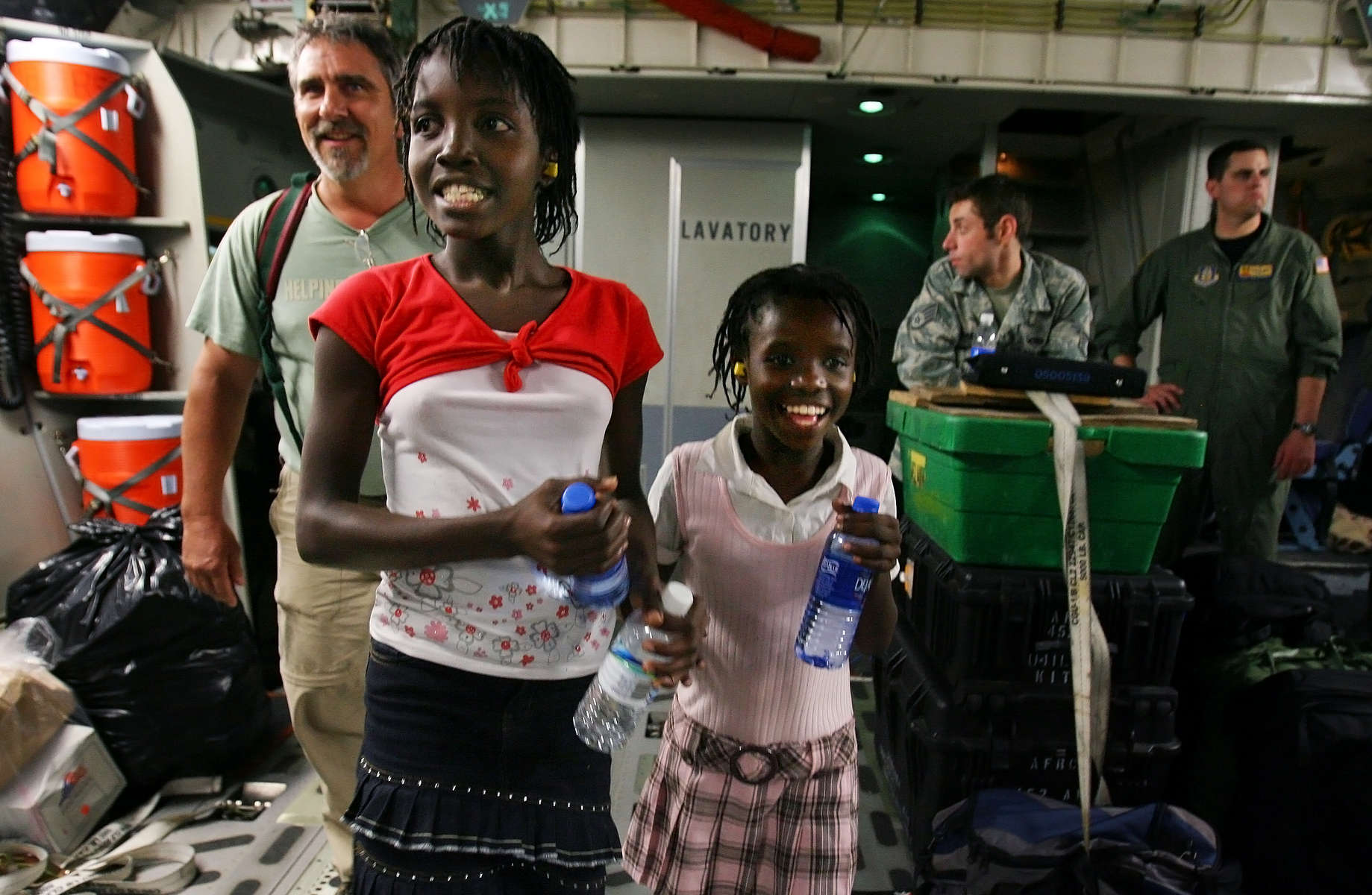 Doug Fry, left, and the two daughters he adopted, Jona Tyuste Fry, 12, and Ginette St-Louis Fry, 11, board the March Air Reserve Base C-17 before leaving Haiti. (The Press-Enterprise/ Mark Zaleski)