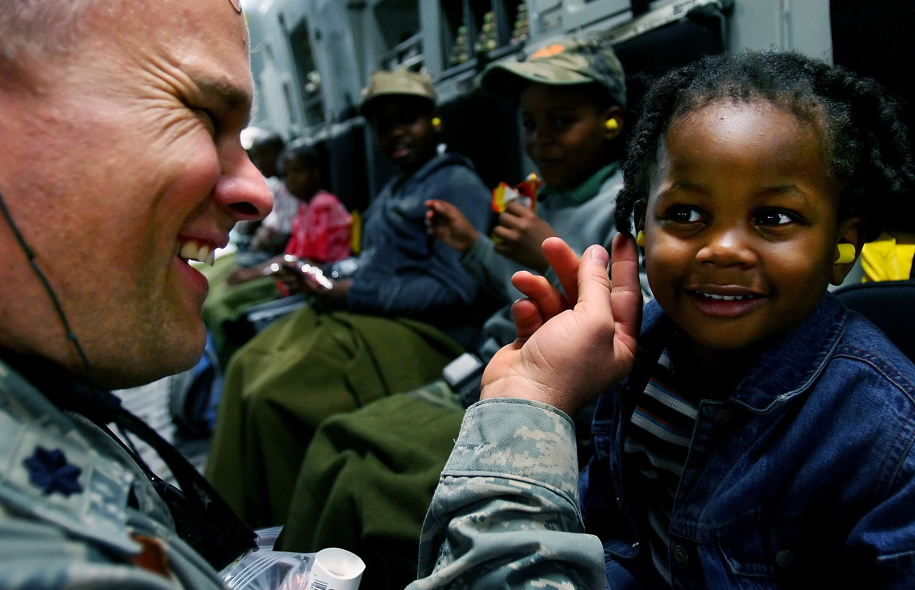 Scott Air Force Base Lt. Col. Randon Draper puts ear plugs in a Haitian girl in the cargo bay of a March Air Reserve Base C-17. (The Press-Enterprise/ Mark Zaleski)