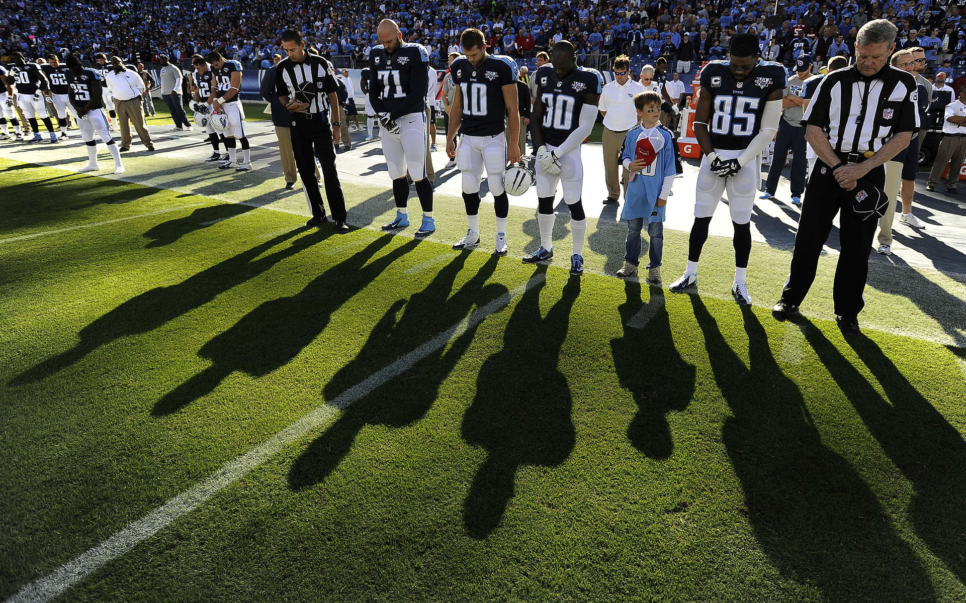 Tennessee Titans players take part in a moment of silence in tribute to the late Bum Phillips before an NFL football game against the San Francisco 49ers on Oct. 20, 2013, in Nashville, Tenn. Phillips, the former Houston Oilers head coach, died Oct. 18, 2013. (AP Photo/ Mark Zaleski)