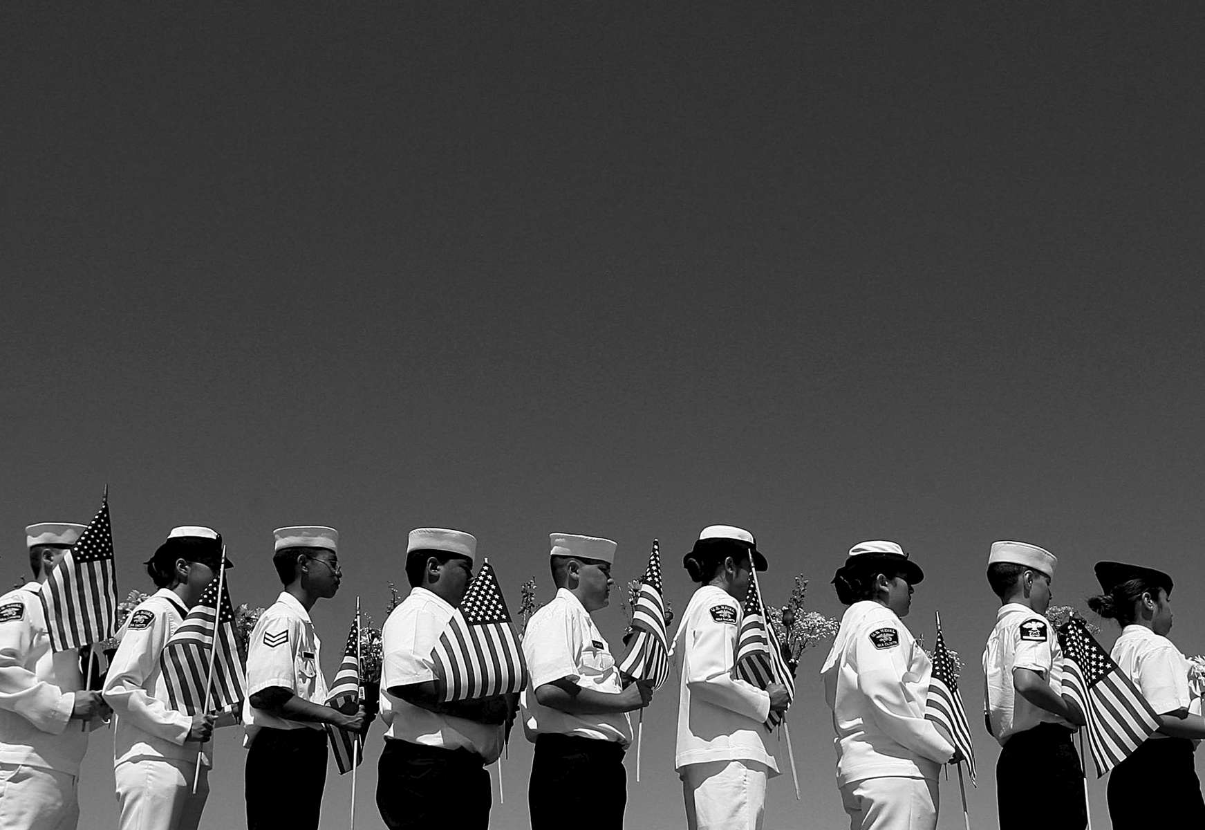 Members of the United States Navel Sea Cadets Corpsfrom March Air Reseve Base stand at attention beforeplacing American flags and flowers at gravesites after a Memorial Day ceremony at Riverside National Cemetery.(The Press-Enterprise/ Mark Zaleski)