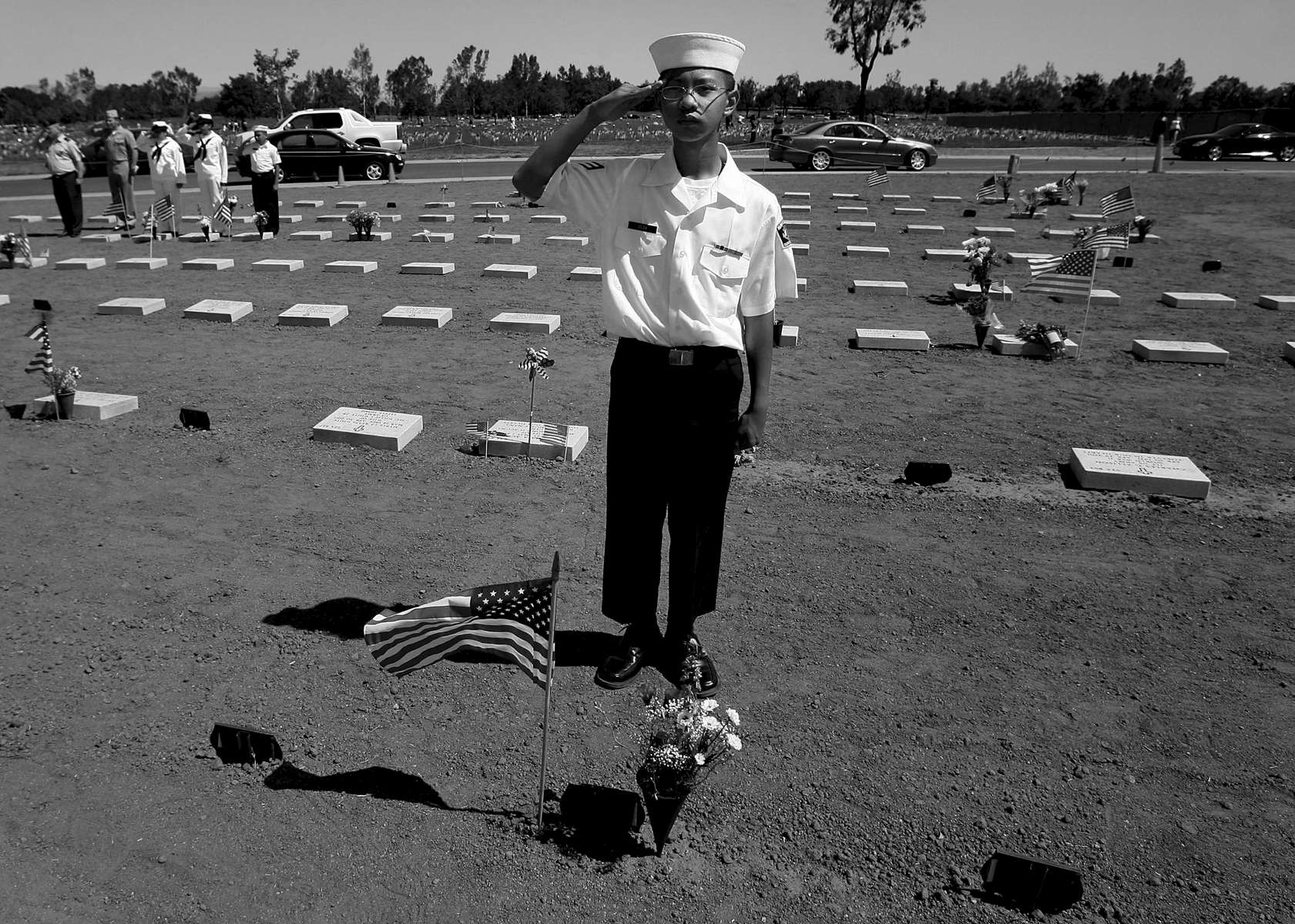 Christian Vilda of the United States Navel Sea Cadets Corps salutes after placing the American flag and flowers by a gravesite at Riverside National Cemetery. (The Press-Enterprise/ Mark Zaleski)