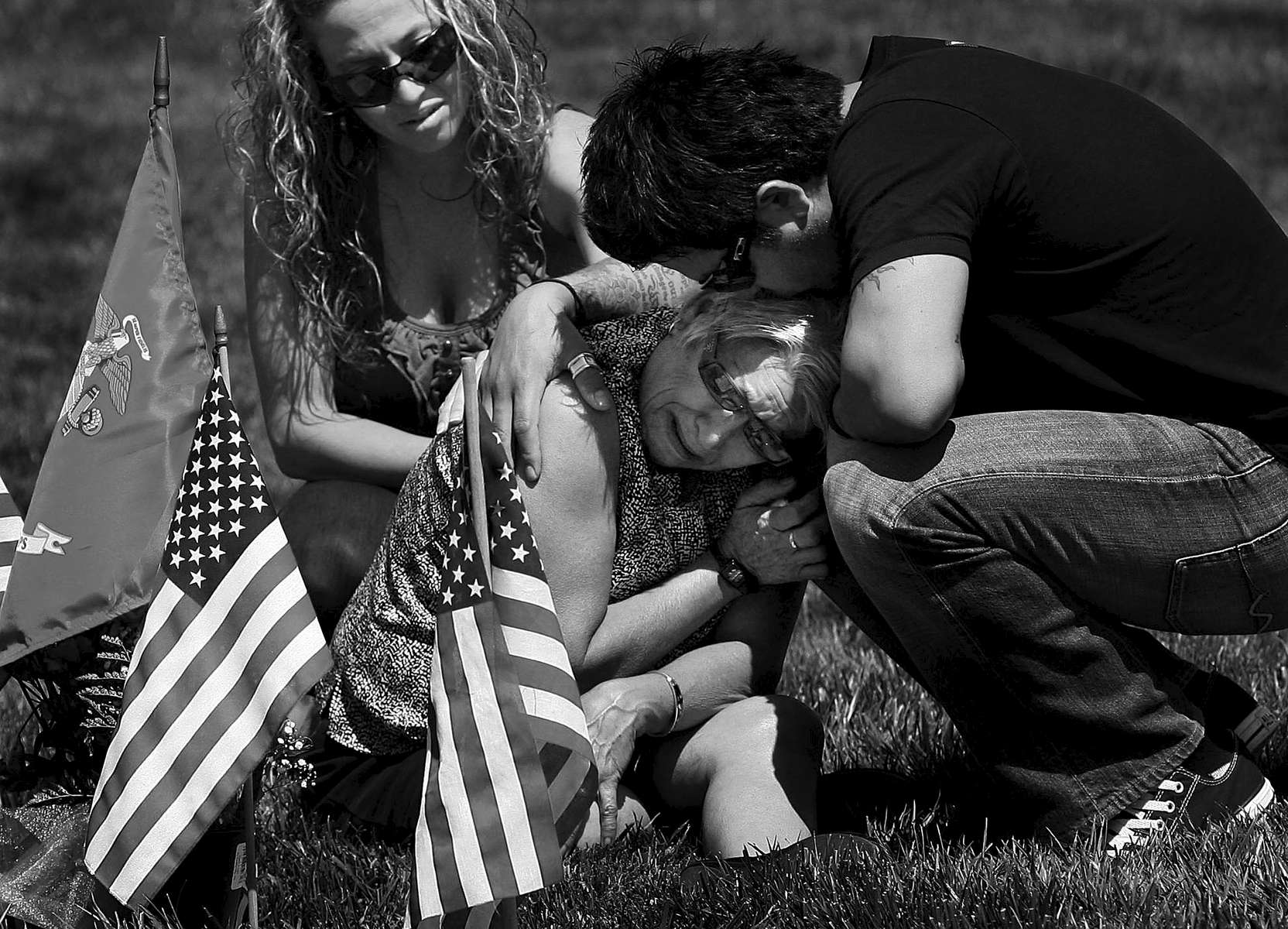 Anthony Gonzalez and his wife, Darcy, comfort their mother, Gloria Gonzalez while visiting the gravesite of Anthony's father and Gloria's husband, United State Marine Corps Master Gunny Sgt. Phillip Gonzalez atthe Riverside National Cemetery on Memorial Day.(The Press-Enterprise/ Mark Zaleski)