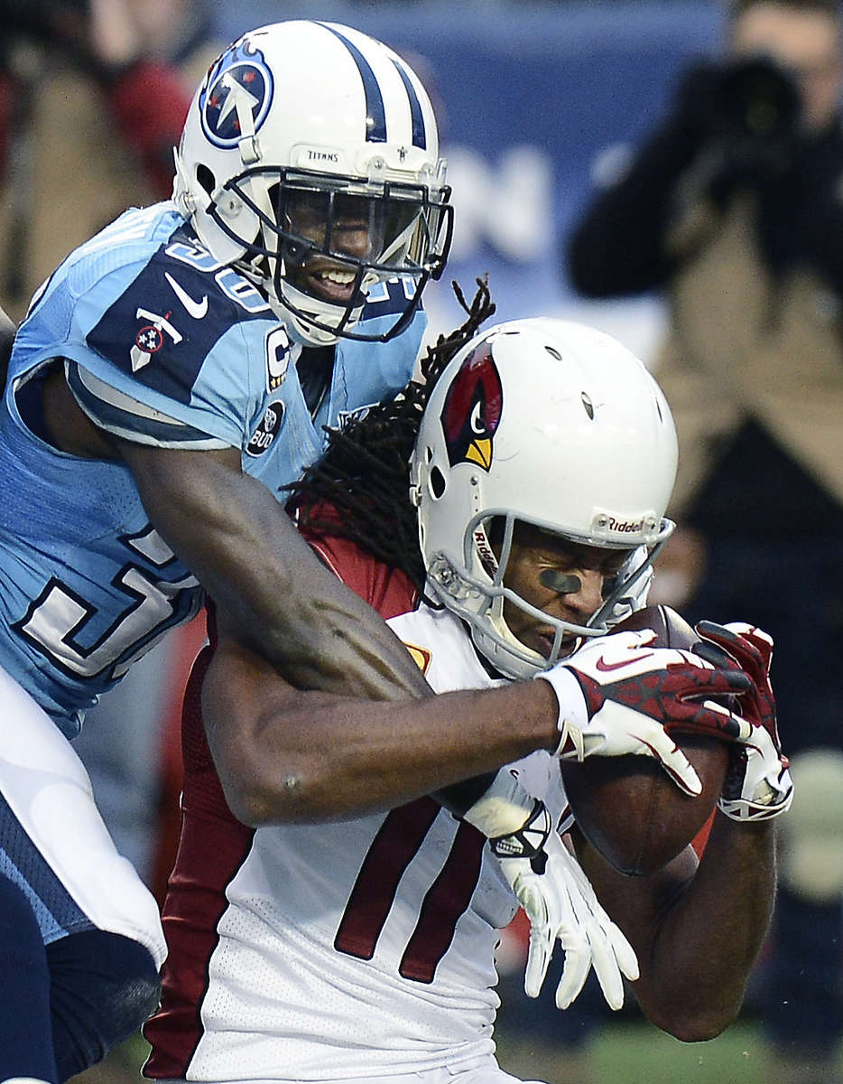 Arizona Cardinals wide receiver Larry Fitzgerald can't hang onto a pass as he is defended by Tennessee Titans cornerback Jason McCourty in the second quarter of an NFL football game Dec. 15, 2013, in Nashville, Tenn. (AP Photo/ Mark Zaleski)