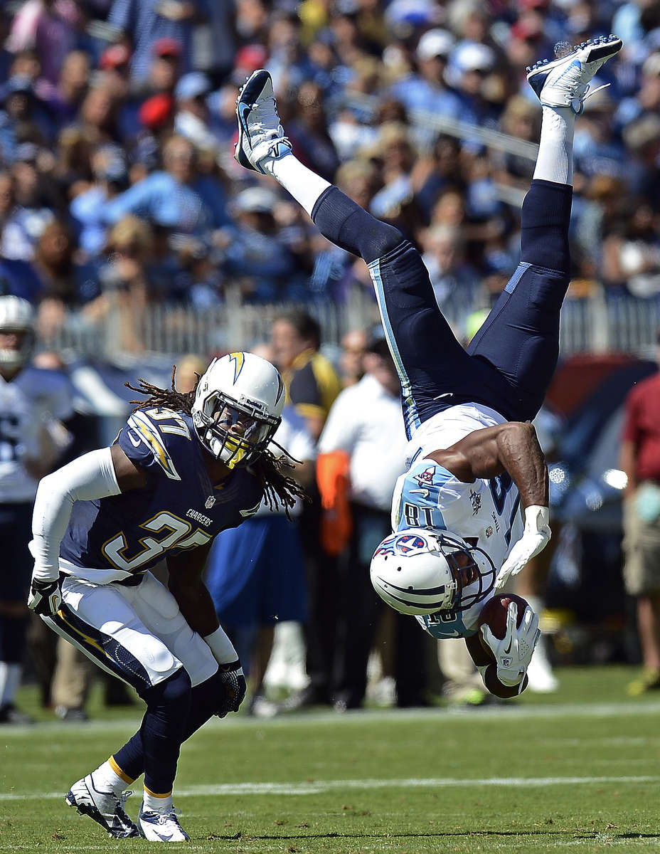 Tennessee Titans wide receiver Kenny Britt flips upside down after making a catch as he is defended by San Diego Chargers defensive back Jahleel Addae in the second quarter of an NFL football game on Sept. 22, 2013, in Nashville, Tenn. Britt was unable to holdonto the ball and the pass was incomplete. (AP Photo/ Mark Zaleski)