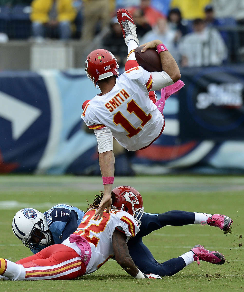 Kansas City Chiefs quarterback Alex Smith flips over Tennessee Titans cornerback Cory Sensabaugh and Chiefs wide receiver Dexter McCluster in the secondquarter of an NFL football game on Oct. 6, 2013, in Nashville, Tenn. (AP Photo/ Mark Zaleski)