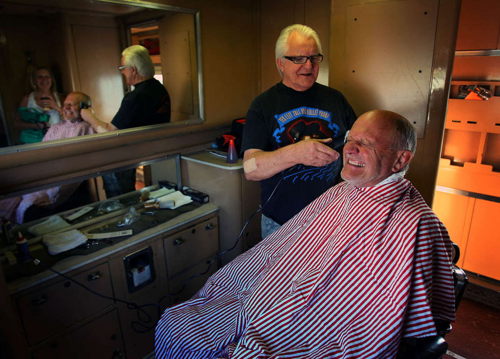 Carl Hunt, a Barstow barber for 47 years, hopes he doesn't cut anything but hair from Wayne Soppelandas the train rocks back and forth on the tracks. Hunt offered to cut hair on the 1949 Overland Trail rail car barber shop during the Kelso Flyer train ride.(The Press-Enterprise/ Mark Zaleski)