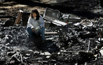 Tess Najarian sits in the rubble of her burned home on Holcomb Creek Drive while visiting the site for the first time since the Slide Fire destroyed it. Residents from Green Valley Lake, Calif., were allowed to see their neighborhood after mandatory evacuation restrictionswere lifted. (The Press-Enterprise/ Mark Zaleski)
