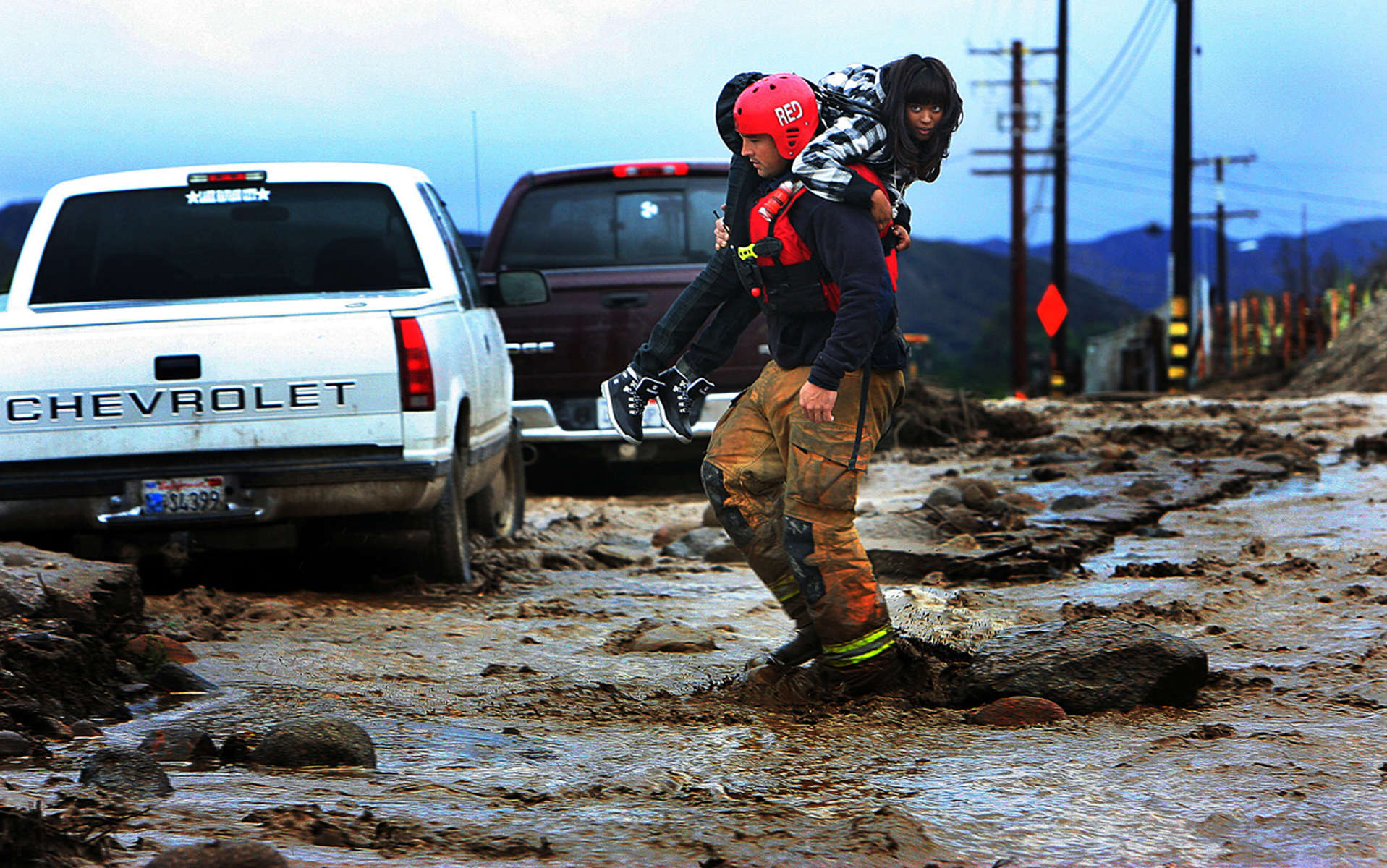Redlands firefighter Chris Randolph rescues a woman from her car after a flash flood washed out San Timoteo Canyon Road in Redlands, Calif. Six cars were stuck in mud and debris from the flash flood. (The Press-Enterprise/ Mark Zaleski)