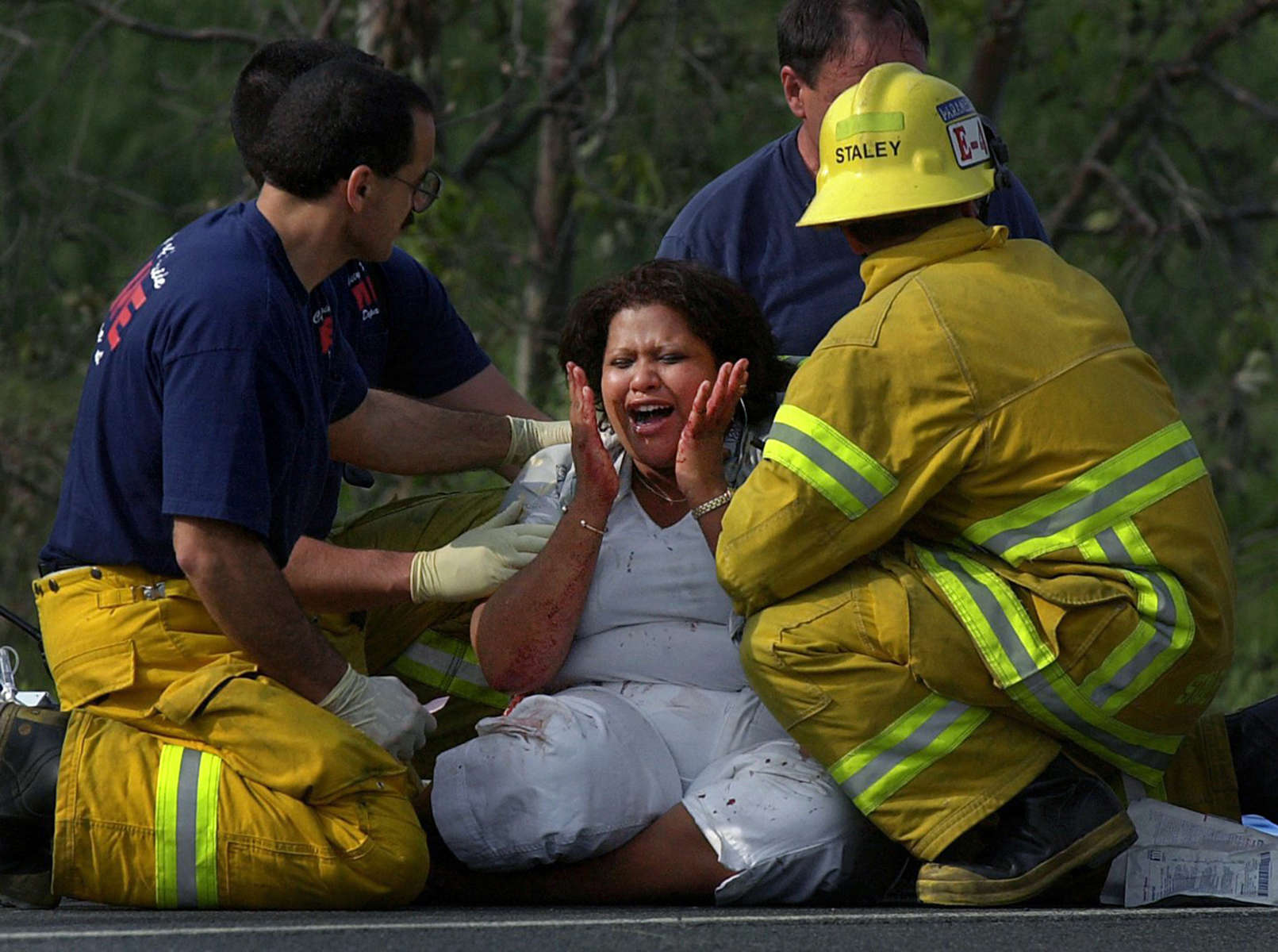 A woman is comforted by Riverside County and Colton City firefighters after learning her daughter died in a single car rollover on Interstate 215 in Colton, Calif.(The San Bernardino Sun/ Mark Zaleski)