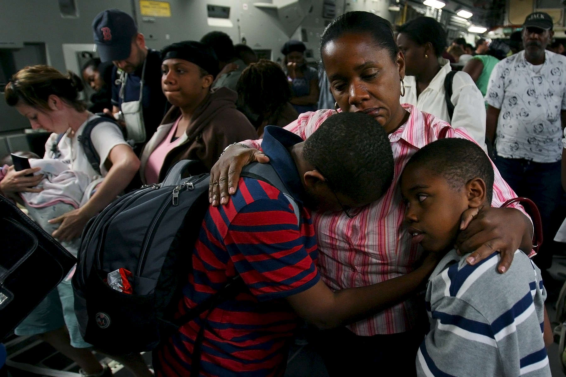 Daphnee Toban hugs her children Olivier Carl, left, and Sebastian Charles in the cargo bay of a March Air Reserve Base C-17 aircraft after arriving at Orlando Sanford International Airport in Fla. Daphnee's children were visiting their grandmother in Haiti when the earthquake hit. (The Press-Enterprise/ Mark Zaleski)