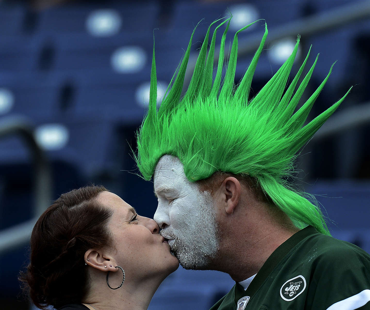 New York Jets fans Ana Hall and Rick Martin kiss as they watch players warm up before an NFL football game between the Jets and the Tennessee Titans on Sept. 29, 2013, in Nashville, Tenn. (AP Photo/ Mark Zaleski)