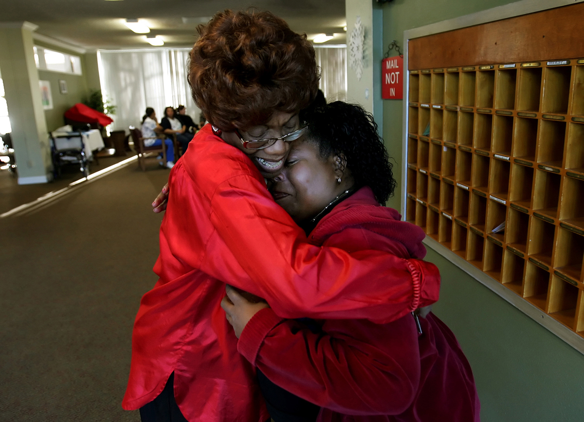 Resident Ada Mitchell, left, consoles Plymouth Tower business office manager Nanette Caldwell as they say goodbye to each other. Caldwell was not offered a job by the new owner, the Ensign Group. (The Press-Enterprise/ Mark Zaleski)