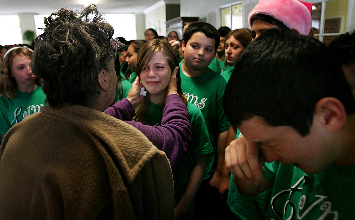 Resident Audrey Lofstrom, 80, left, comforts Maddie Hiatt, 13, of the Jurupa Middle School Choir after she started crying while singing Christmas songs for residents and staff before the Plymouth Tower closes. Fellow choir student Chase Giseo, 12, right, also startsto cry after the event ended. The choir has been entertaining the residents for the last ten years. (The Press-Enterprise/ Mark Zaleski)