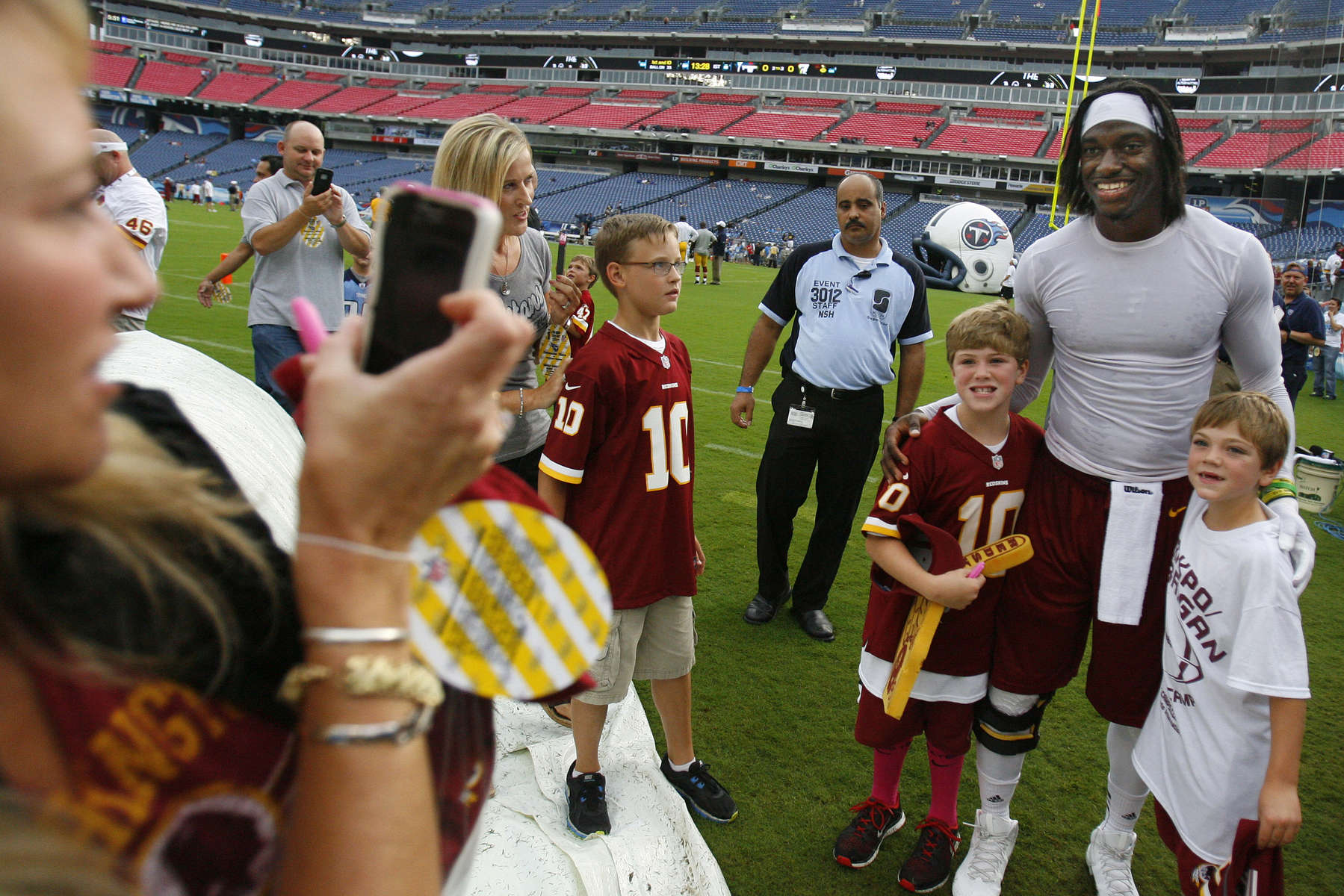 Washington Redskins quarterback Robert Griffin III poses for photos with fans before a preseason NFL football game against the Tennessee Titans on Aug. 8, 2013, in Nashville, Tenn. (AP Photo/ Mark Zaleski)