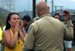 California Highway Patrol Officer C.A. Dosstells Terria Robertson that she can't go back to her home on Sycamore Drive because the Grand Prix Fire is burning in Lytle Creek, Calif. (The Press-Enterprise/ Mark Zaleski)