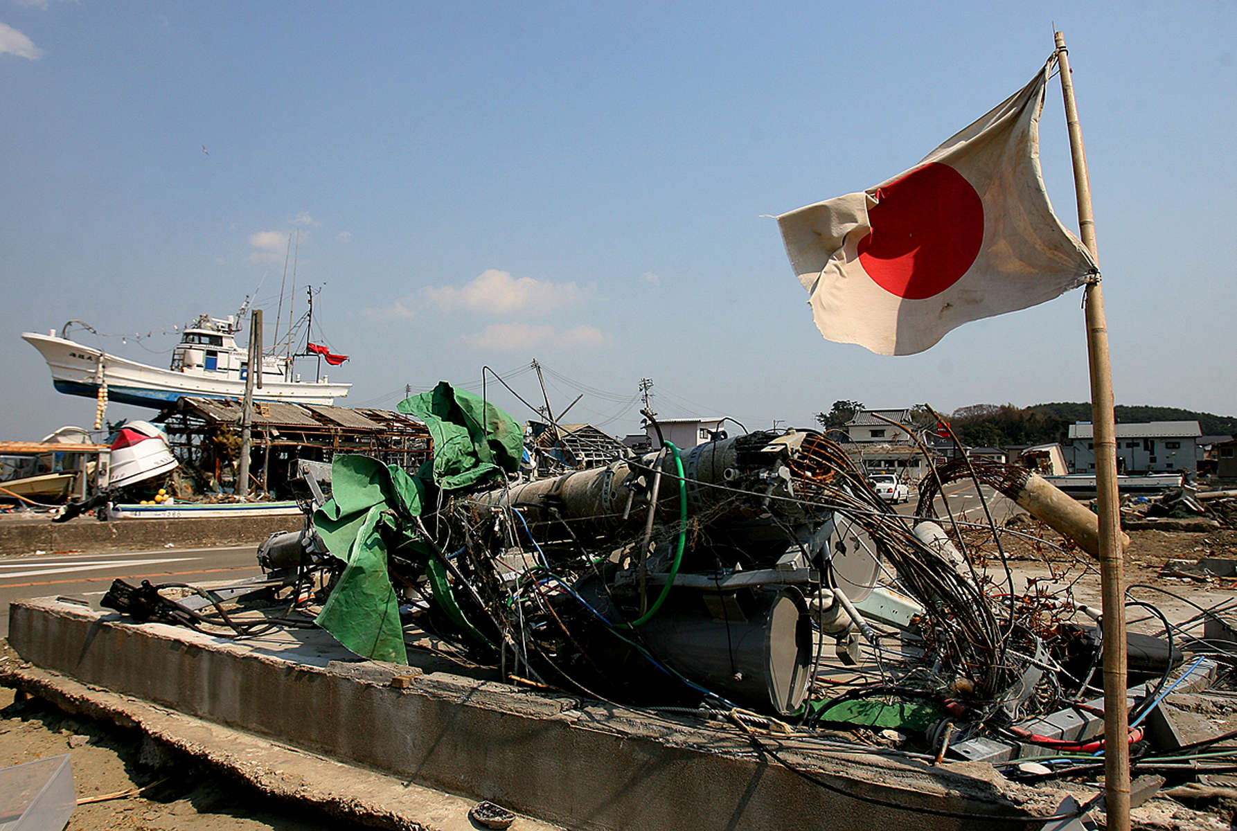 The Japanese flag is displayed as a fishing boat rests on top of a damaged building in Shichigahama, a fishing town of northern Sendai, Japan. (The Press-Enterprise/ Mark Zaleski)