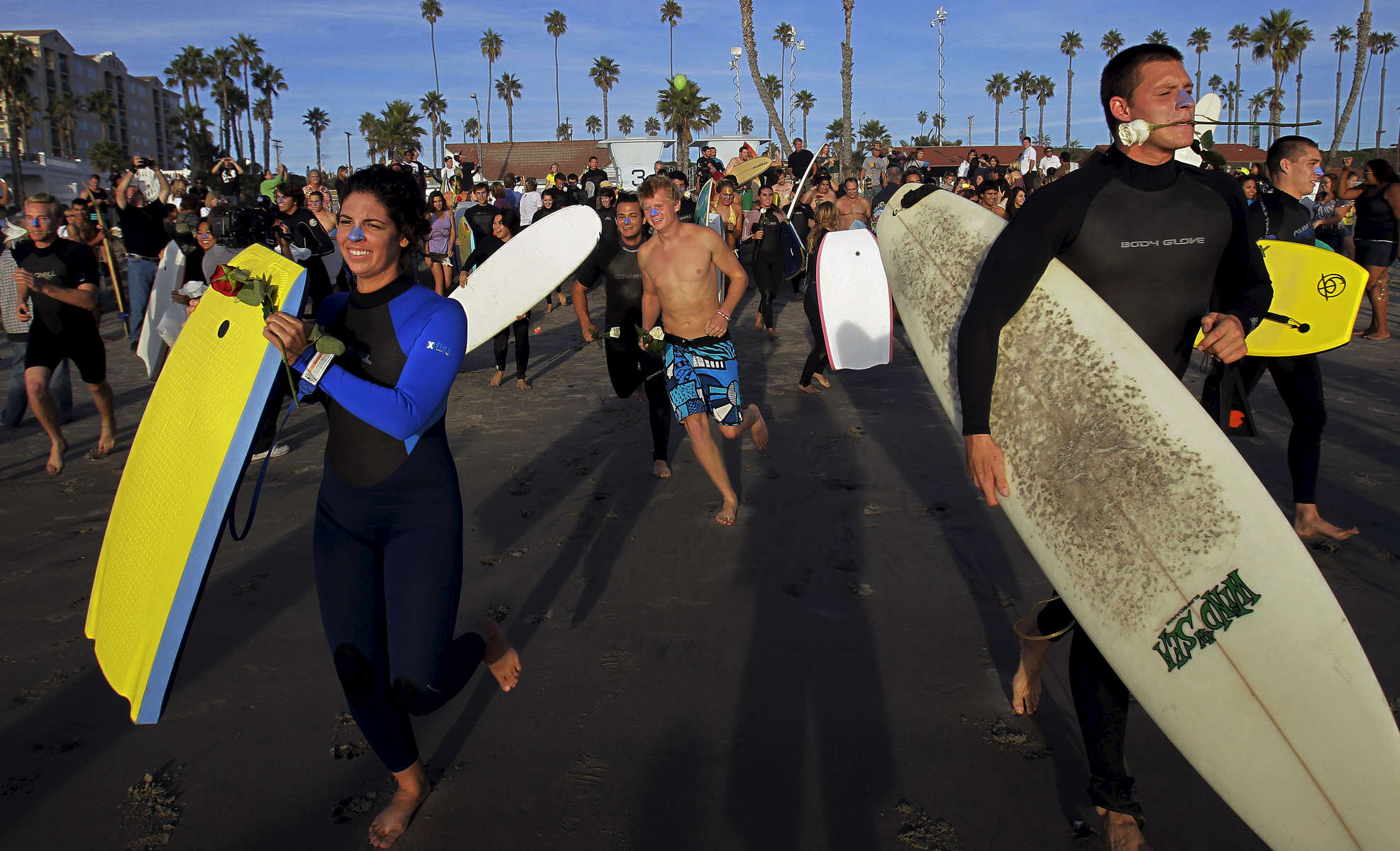 Body boarders and surfers run into the Pacific Ocean in memory of Lucas Ransom during a paddle-out memorial near the Oceanside Pier. (The Press-Enterprise/ Mark Zaleski) 