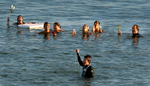 Family and friends gather near Travis Ransom, bottom, in the Pacific Ocean as they shout out Travis's brother name Lucas during a paddle-out memorial near the Oceanside Pier. (The Press-Enterprise/ Mark Zaleski) 