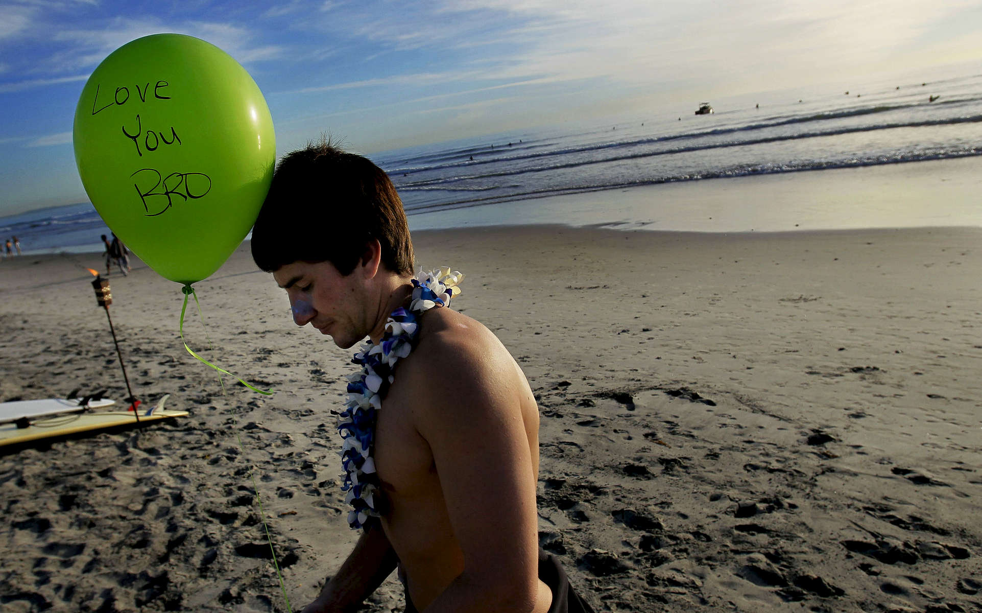 Lucas Ransom brother, Travis, spends a moment alone before releasing a balloon in memory of his brother after the paddle-out memorial.(The Press-Enterprise/ Mark Zaleski) 
