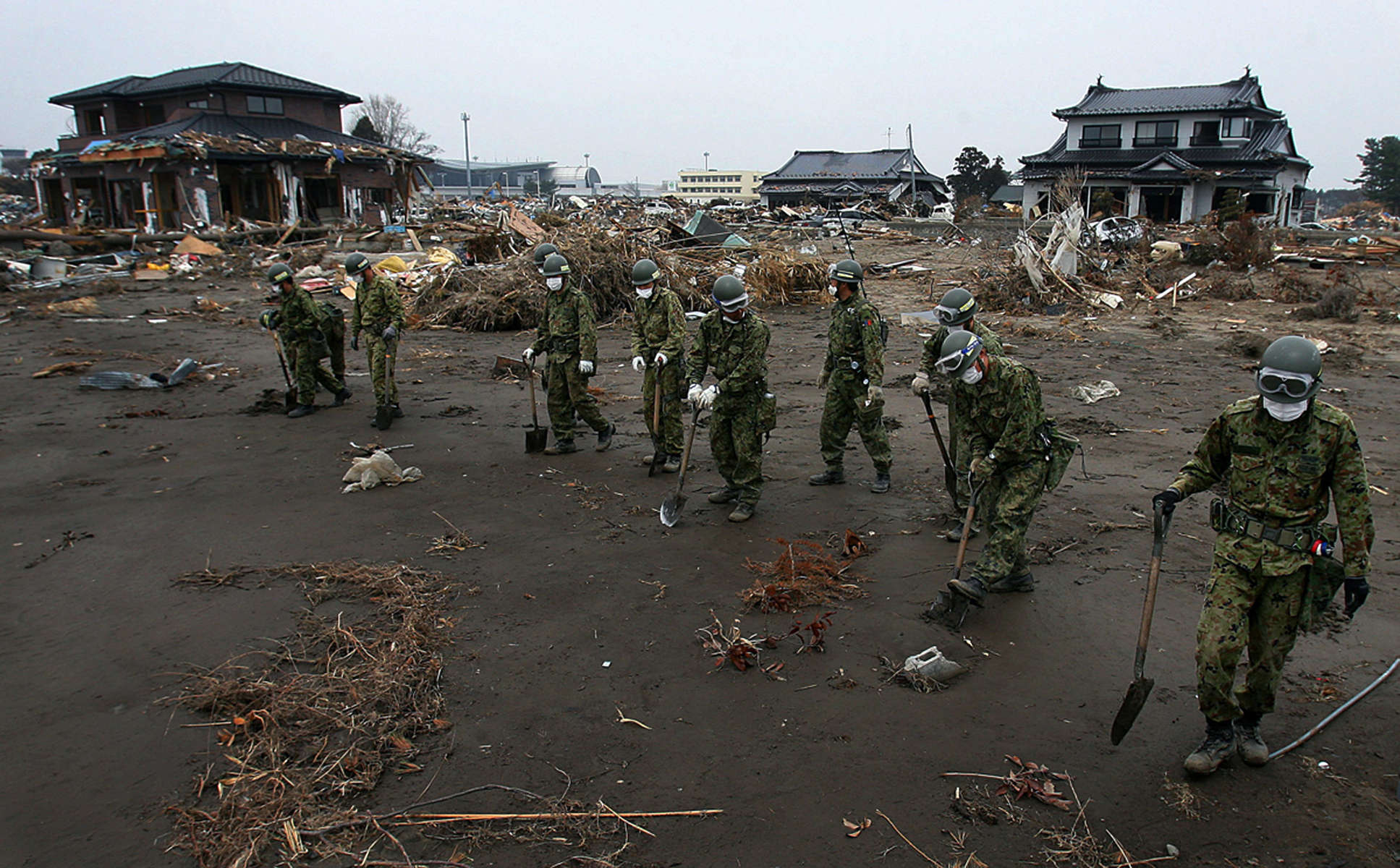 Japan's Ground Self-Defense force members search through debris near the Sendai Airport looking for victims after a 9.0 earthquake and tsunami devastated Sendai in the Miyagi Prefecture of Japan. (The Press-Enterprise/ Mark Zaleski)