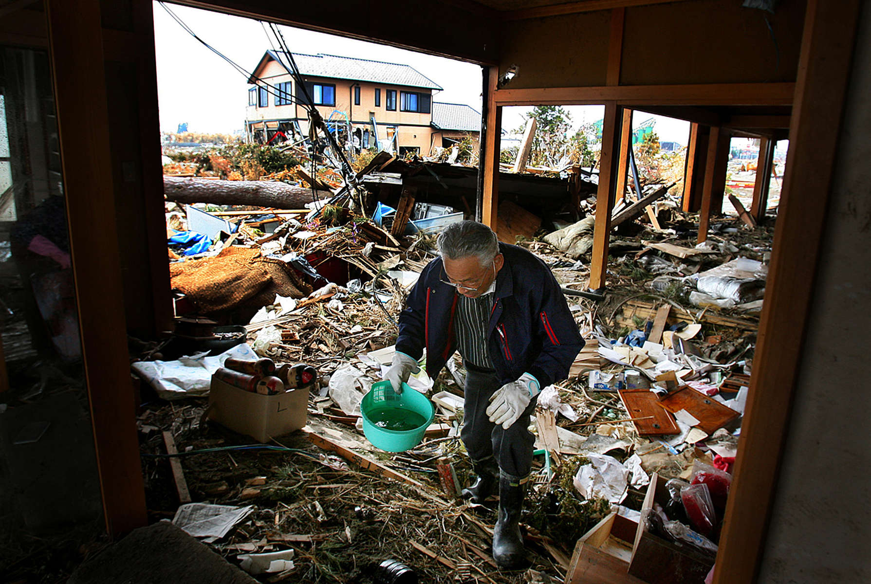 Kimio Sugai, 71, searches through the ruins of his home hoping to find anything he can use after a 9.0 earthquake and tsunami devastated Sendai in the Miyagi Prefecture of northern Japan on March 11, 2011. Kimio and his wife, Katsuko,lost their son, who was firefighter working when the tsunami hit. (The Press-Enterprise/ Mark Zaleski)