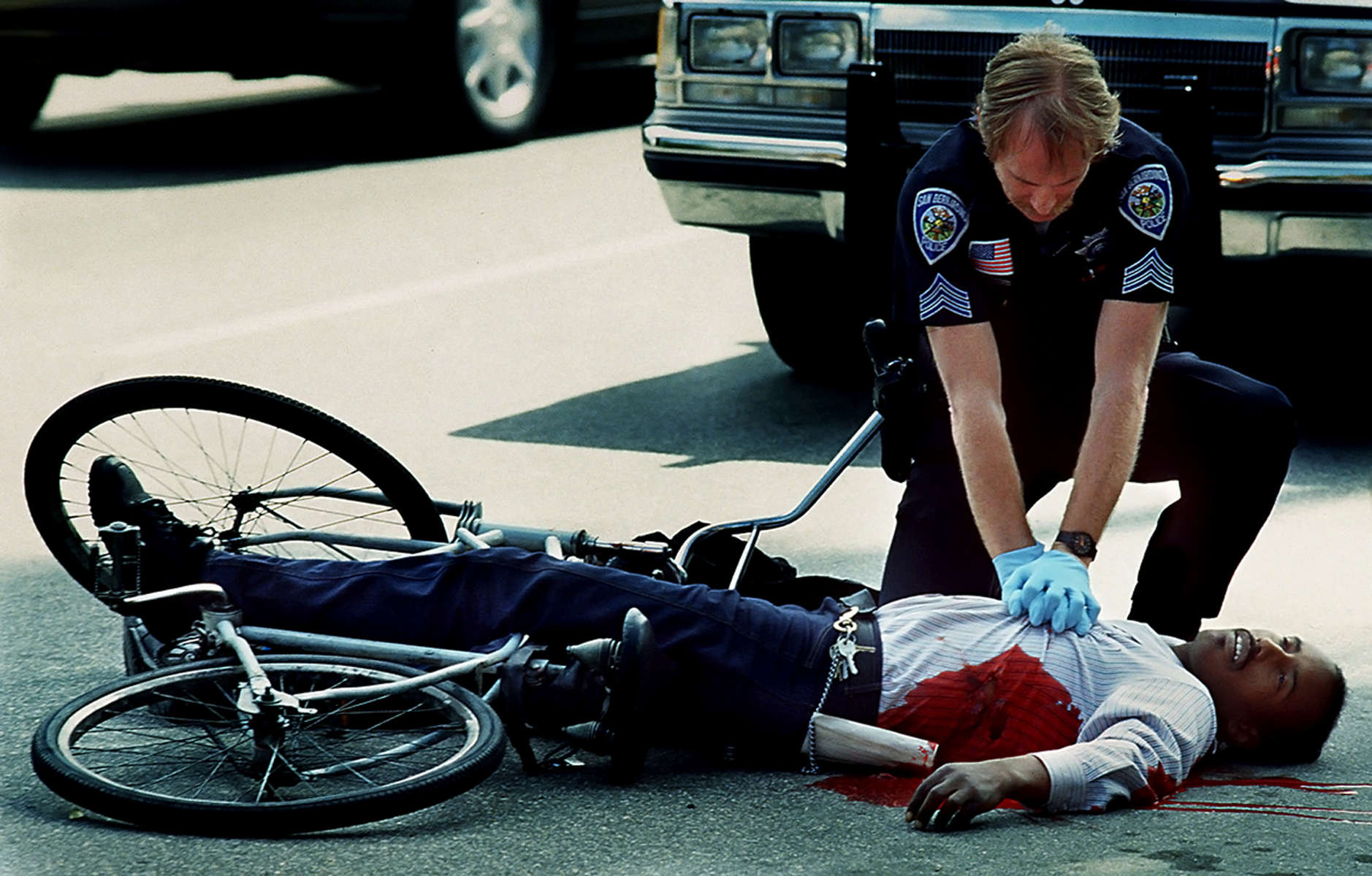 A San Bernardino police officer Mike Wilson attempts to revive a shooting victim near Waterman Avenuein San Bernardino, Calif. The city was ranked No. 1 in the nation for homicides in the early 1990s. (The San Bernardino Sun/ Mark Zaleski)