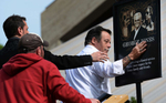 Fans touch a poster of George Jones as they enter theGrand Ole Opry House for the funeral of country musicstar George Jones on May 2, 2013, in Nashville, Tenn. Jones, a country music legend who had No. 1 hits in four separate decades. (AP Photo/ Mark Zaleski)