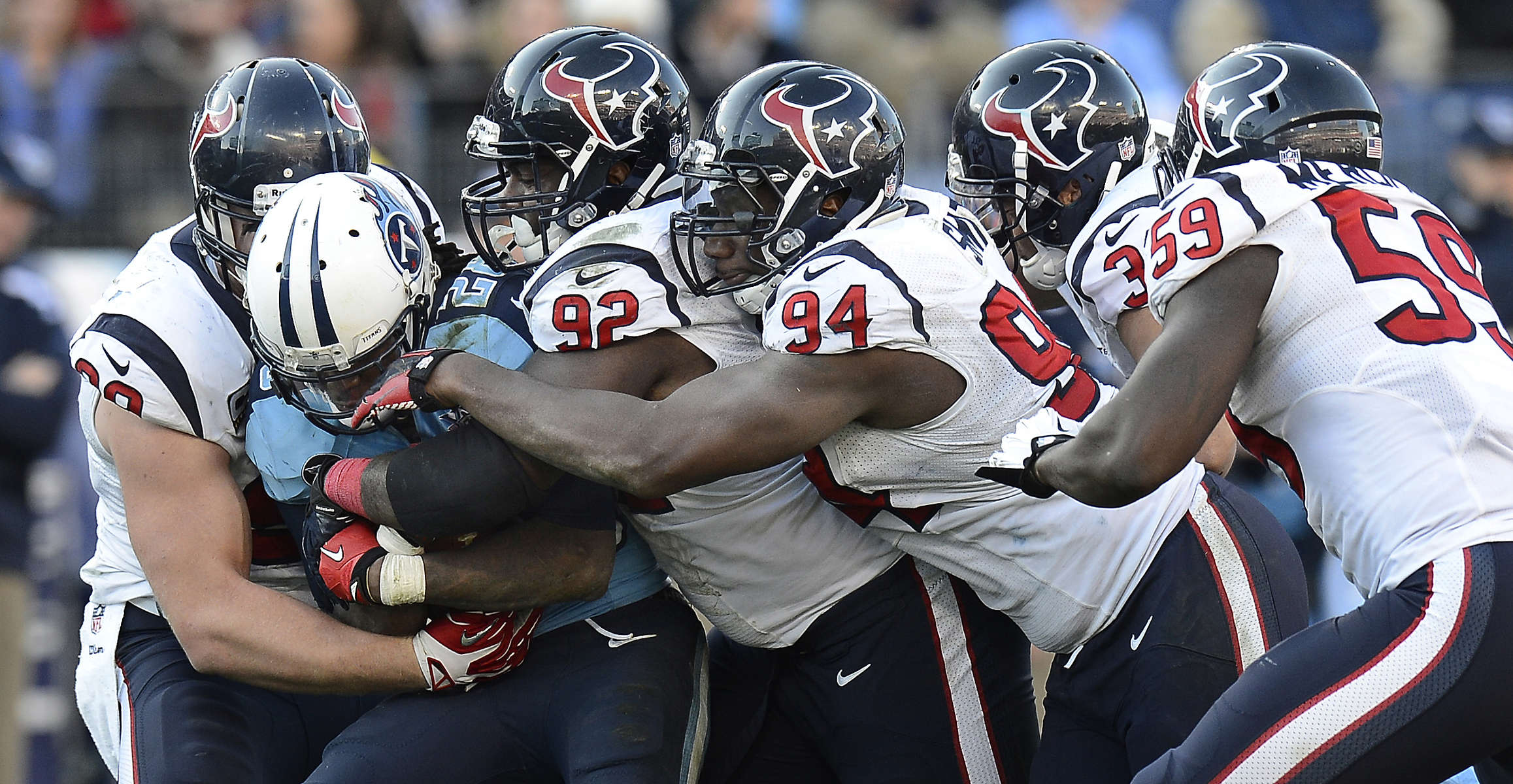 Tennessee Titans running back Chris Johnson is stoppedby Houston Texans defenders J.J. Watt, Earl Mitchell and Antonio Smith in the fourth quarter of an NFL football game on Dec. 29, 2013, in Nashville, Tenn. The Titans won 16-10. (AP Photo/ Mark Zaleski)