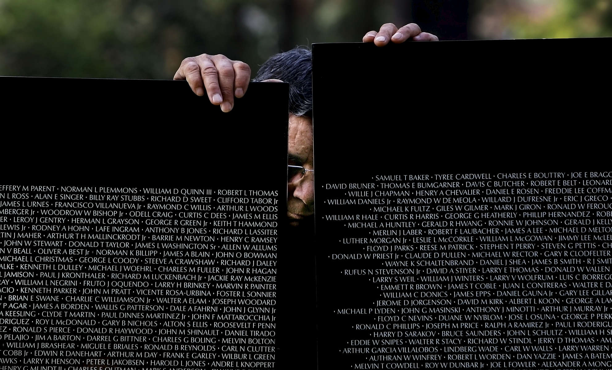 Marcos Ramirez, 67, of Loma Linda, Calif., holds up two panels of the Vietnam Veterans Memorial Moving Wall during its construction for a temporary exhibit in Redlands, Calif. (The Press-Enterprise/ Mark Zaleski)