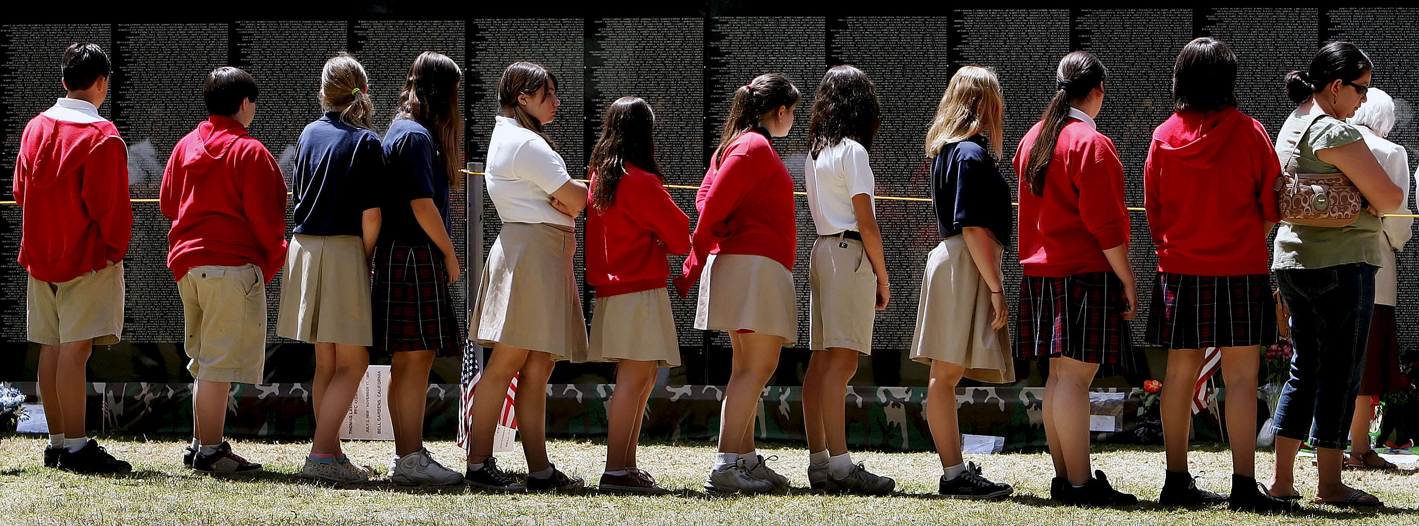 Students from Sacred Heart Academy in Redlands, Calif., walk by the The Moving Wall looking at the names of the fallen soldiers during a class outing.(The Press-Enterprise/ Mark Zaleski)