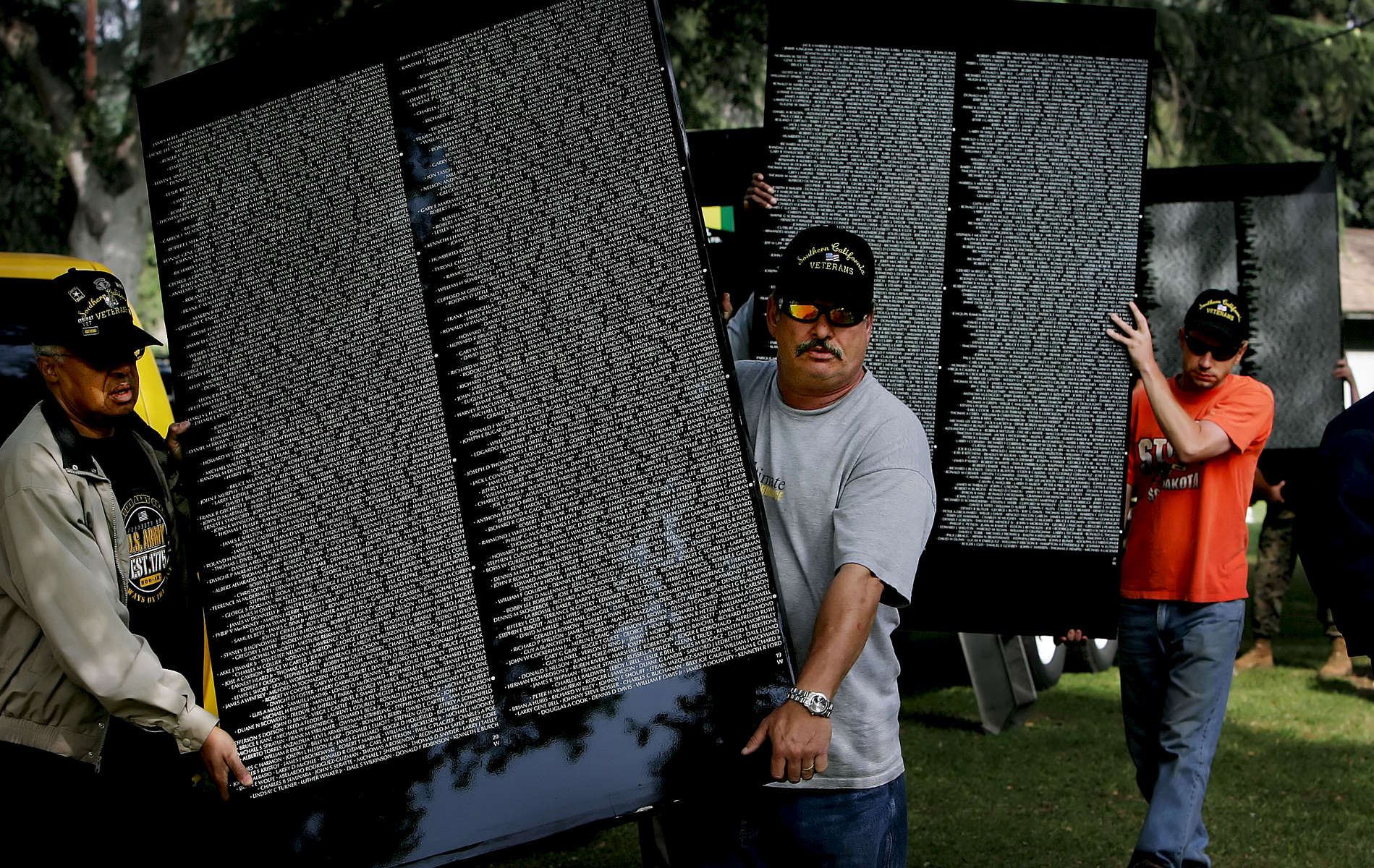 The Vietnam Veterans Memorial Moving Wall is a half-size replica of the memorial located in Washington, D.C., and travels the country honoring the dead and missing Americansfrom the Vietnam War (1959-1975). Volunteers carry several panels to put in place duringconstruction of The Moving Wall in Redlands, Calif. (The Press-Enterprise/ Mark Zaleski)