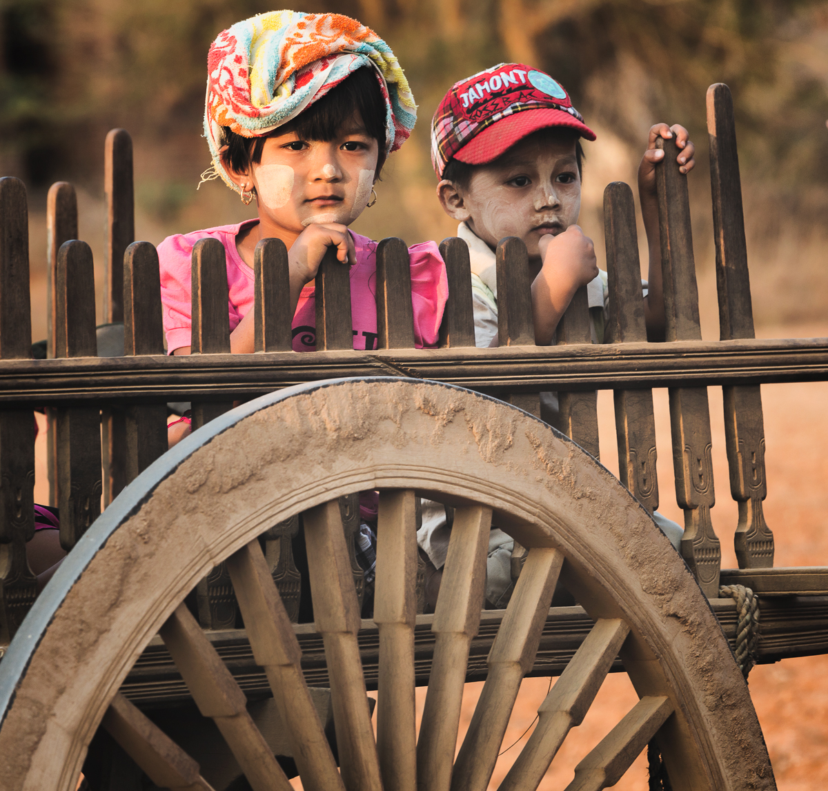 Local siblings riding in oxcarts