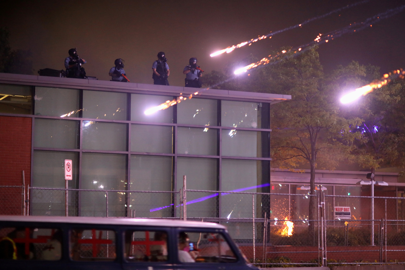 Fireworks rain down near police officers as they hold positions on the roof of their station in Minneapolis, May 29, 2020, after unrest and protests erupted in the aftermath of the death of George Floyd.