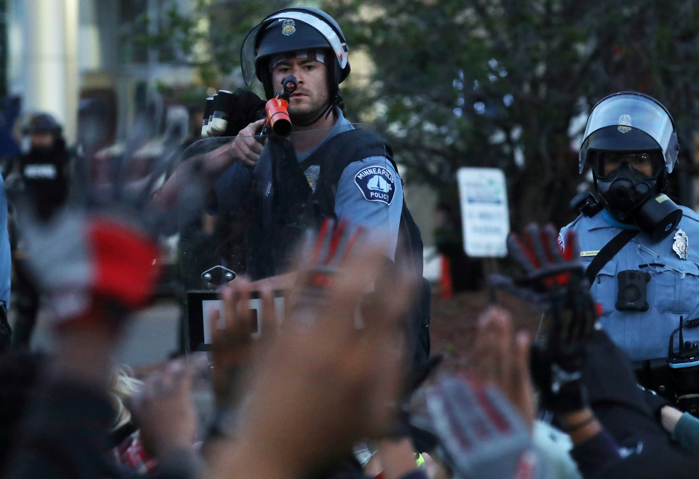 A member of Minneapolis police aims a {quote}less lethal{quote} weapon at seated protesters from a few feet away as they hold their hands up after a group of them were rounded up for a mass arrest following another day of protest calling for justice for George Floyd in Minneapolis May 31, 2020. 