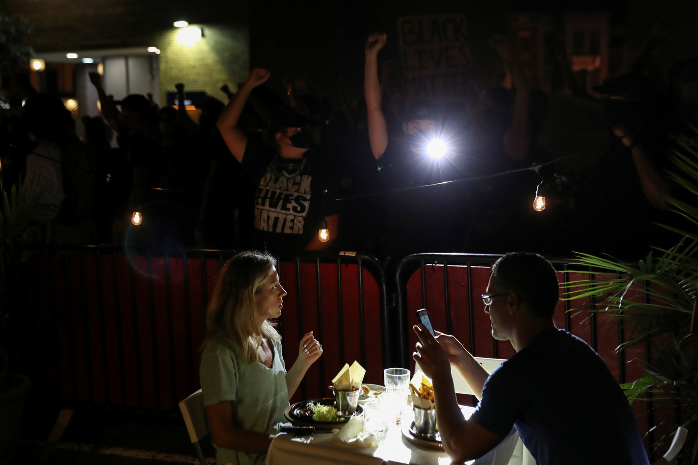 Diners have their meal as protesters tell them about Deon Kay, who died recently after he was shot by local police, in Washington, U.S., September 5, 2020. REUTERS/Leah Millis
