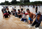 Migrants, part of a caravan traveling to the U.S., make a human chain to pull people from the Suchiate river that separates Guatemala and Mexico in Ciudad Hidalgo in Mexico. 