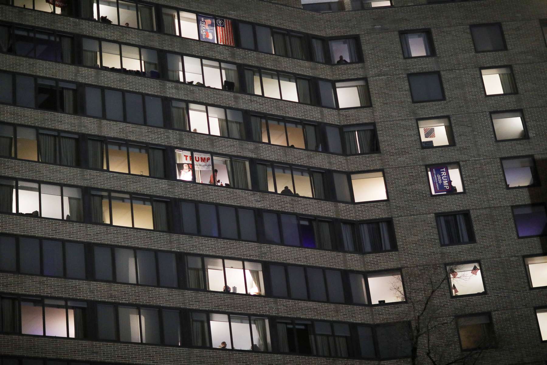 Supporters of U.S. President Donald Trump can be seen in the windows of their hotel rooms as fellow supporters hold a rally in Freedom Plaza near the White House, ahead of the U.S. Congress certification of the November 2020 election results during protests in Washington, U.S., January 5, 2021. 