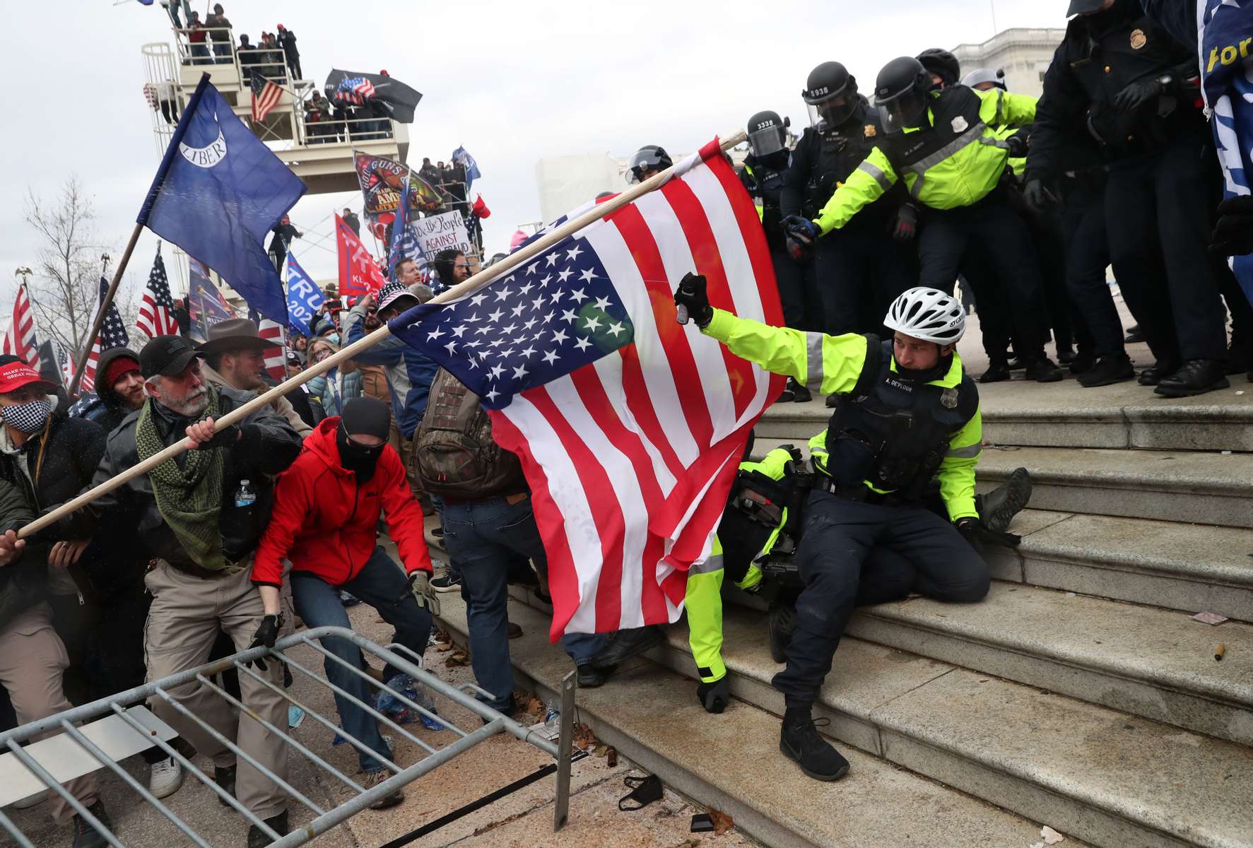 A police officer sprays chemical irritant as he tries to fend off attacks by a mob, many supporters of U.S. President Donald Trump, after a large crowd began attempting to storm the U.S. Capitol building as the U.S. Congress certification of the November 2020 election results went on inside in Washington, U.S., January 6, 2021.