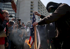 A protester burns a flag that was ripped from a Donald Trump supporter in front of a wall of media outside of the Hyatt Regency during the first day of the California Republican Party Convention which featured speeches from Presidential candidates Donald Trump and John Kasich among others April 29, 2016 in Burlingame, Calif.