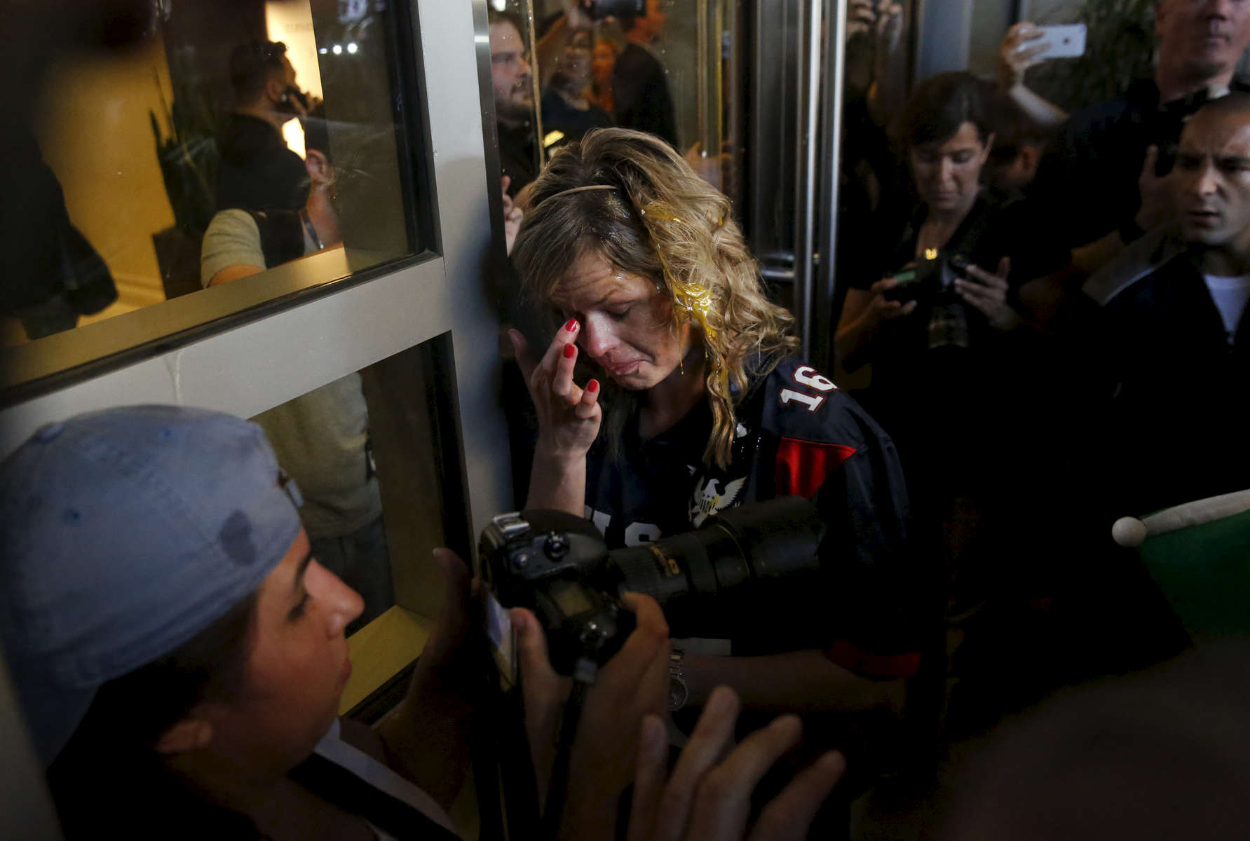 A Donald Trump supporter tries to clear her eyes after being cornered by an anti-Trump crowd and getting hit by multiple eggs near the convention center where presidential candidate Donald Trump held a campaign rally June 2, 2016 in downtown San Jose, Calif.